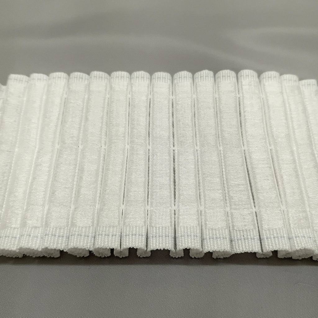 A close up of the back of hook compatible curtain tape ready to be attached to hook tape