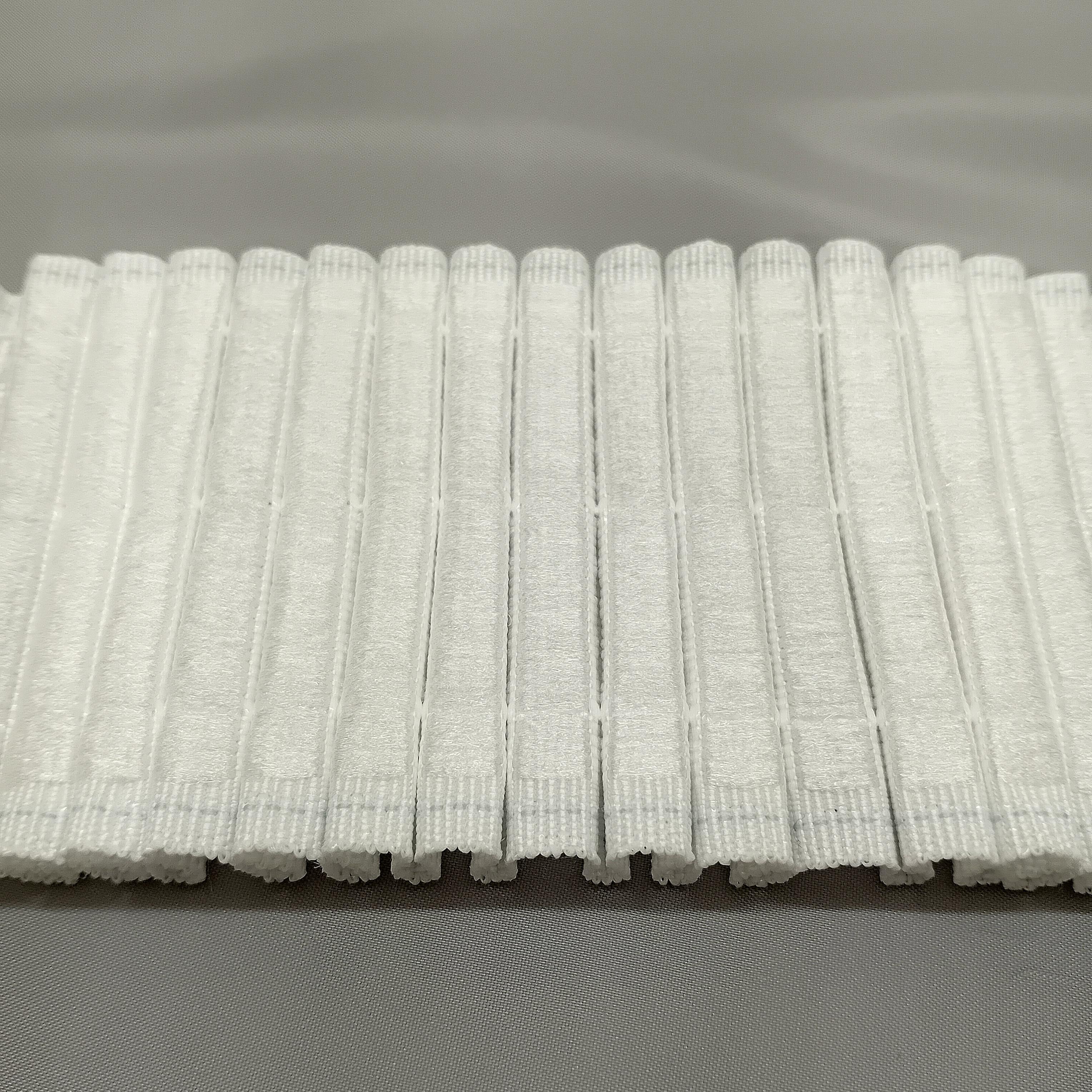 A close up of the back of hook compatible curtain tape ready to be attached to hook tape