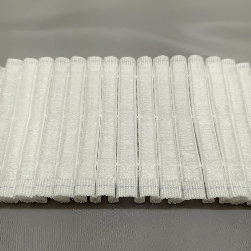 A close up of the back of hook compatible curtain tape ready to be attached to hook tape