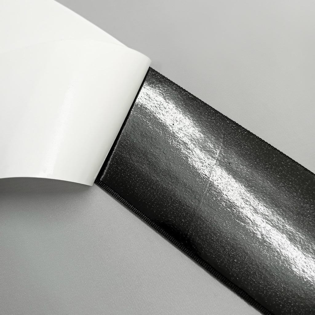 Close up of the back of adhesive loop tape showing the glue under the paper backing 