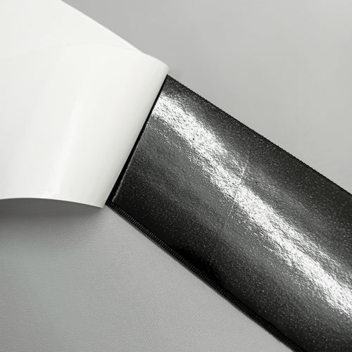 Close up of the back of adhesive loop tape showing the glue under the paper backing 