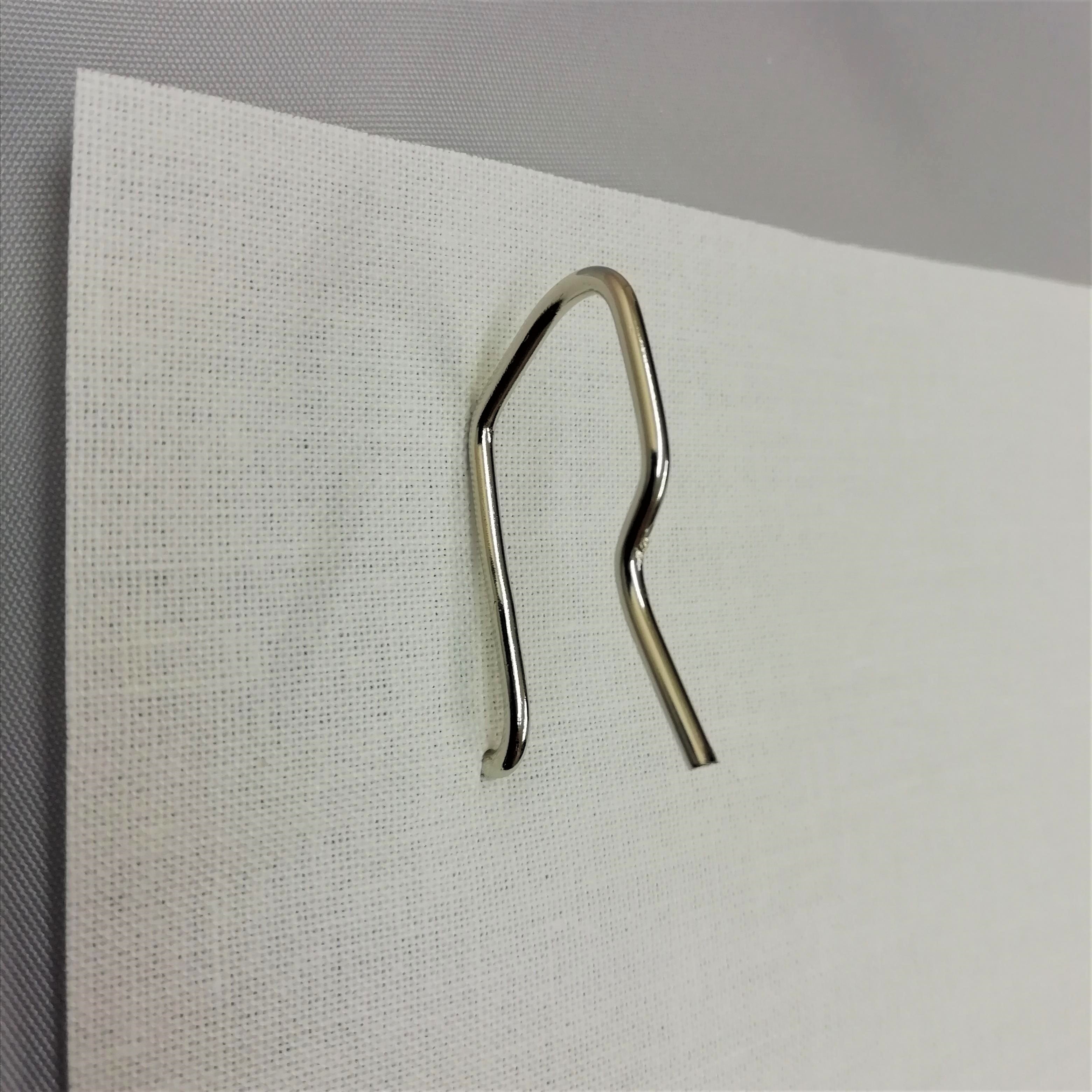 A pin hook pushed through buckram