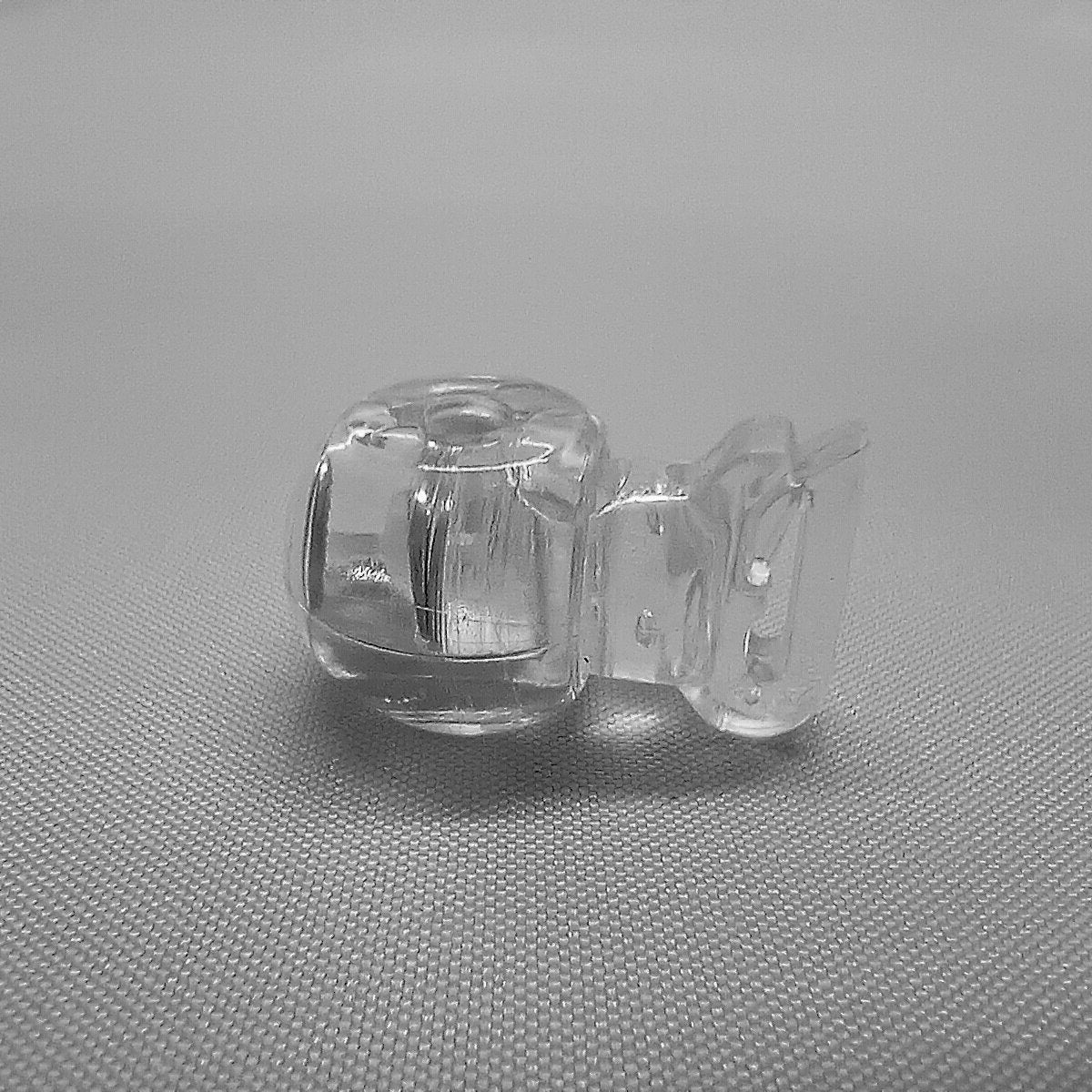 A clear plastic clip in cord stop for clipping onto the tape of roman blinds