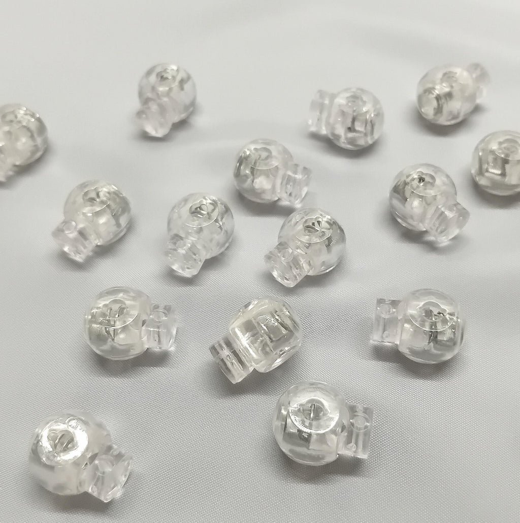 Lots of clear plastic sew in cord stops for sewing into roman blinds